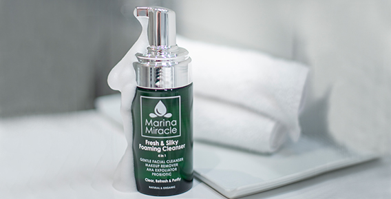Gr&ouml;n flaska med ansiktsreng&ouml;ring fr&aring;n Marina Miracle, placerad p&aring; en vit handduk.