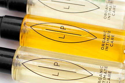 Tre flaskor med intimv&aring;rdsprodukter fr&aring;n Lip Intimate Care ligger uppradade. Flaskorna inneh&aring;ller gula och klara v&auml;tskor, har svarta pumpar och etiketter med texten "LP" och "Organic Intimate Care".