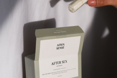 En bild p&aring; en hand som plockar ut en tampong ut ur f&ouml;rpackningen Aima Sense After sex tampong.