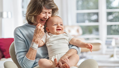 En &auml;ldre kvinna som h&aring;ller i en bebis.